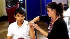 Pupil receiving vaccination from school nurse